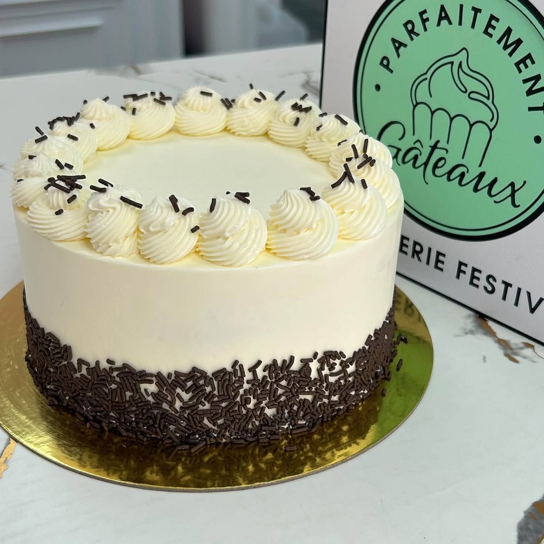 Un gâteau au glaçage blanc et à la base de copeaux de chocolat