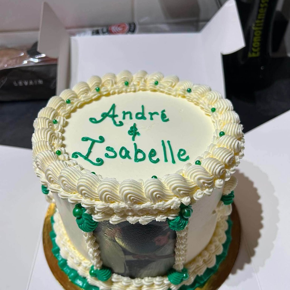 Un gâteau blanc portant les prénoms André et Isabelle